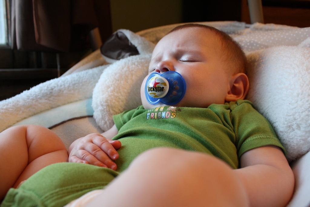 Baby Boy with Pacifier Sleeping in Swing
